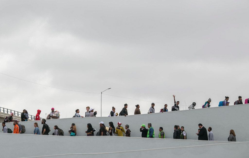 Inmigrantes formados en la frontera de México para entrar a Estados Unidos listos para...