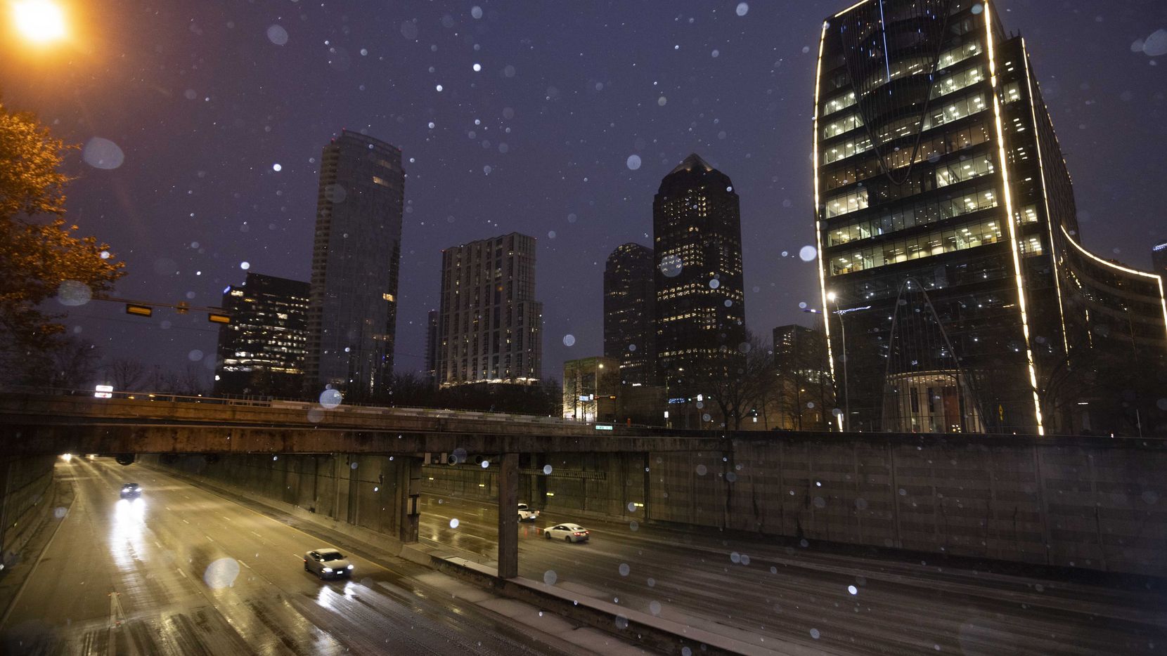 Cars drive along Woodall Rodgers Freeway as sleet falls on Thursday in Dallas. The cold...