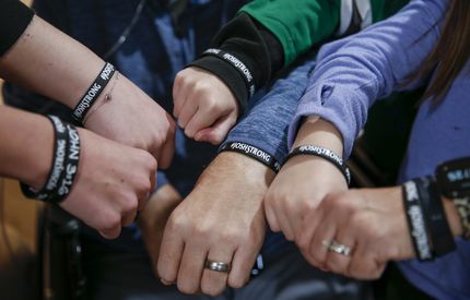 Emily and Josh Welch and their four children wear wristbands that a family friend made to...