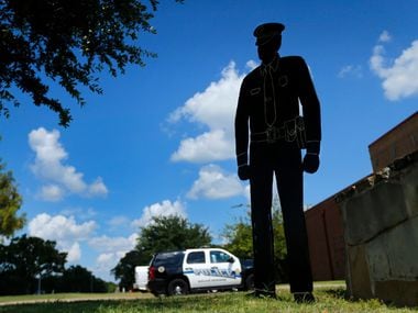 A wooden silhouette of a police officer stands in front of the Balch Springs Police and Fire...
