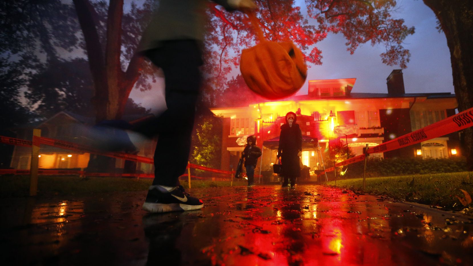 Trick-or-treaters skipped over rain puddles in the historic Swiss Avenue neighborhood of...