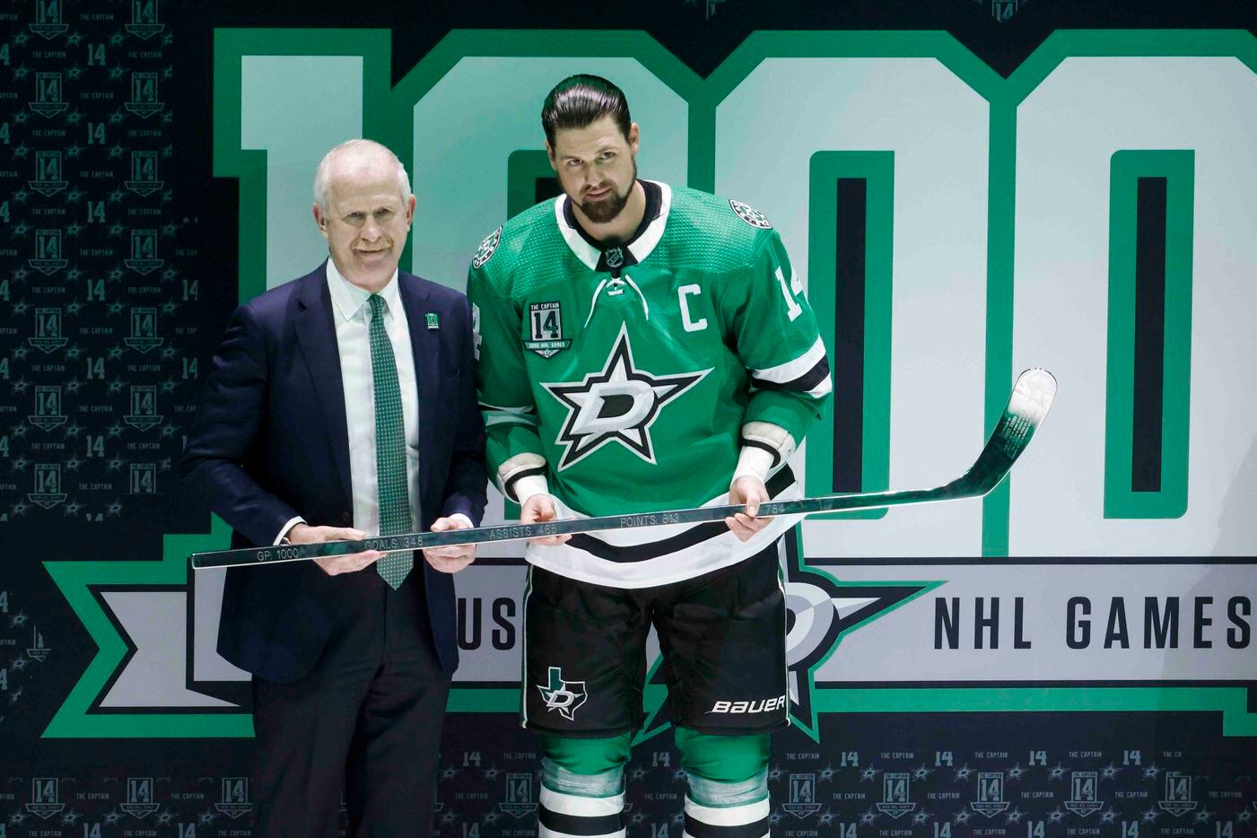 Dallas Stars general manger Jim Nill (left) presents left wing Jamie Benn (14) with a silver...