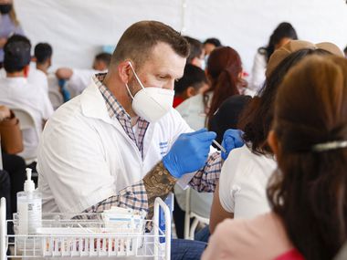 Pharmacy clinical services manager Rob Wheeler administers a COVID-19 vaccine at a vaccination clinic at the Walmart on North Cockrell Hill in Dallas, Wednesday, Dec. 29, 2021.