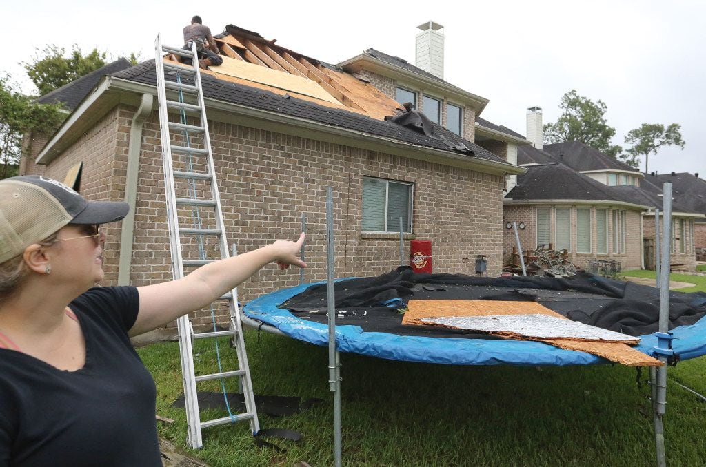Christy Petrie points out the damage on her house after a tornado spawned by Hurricane...
