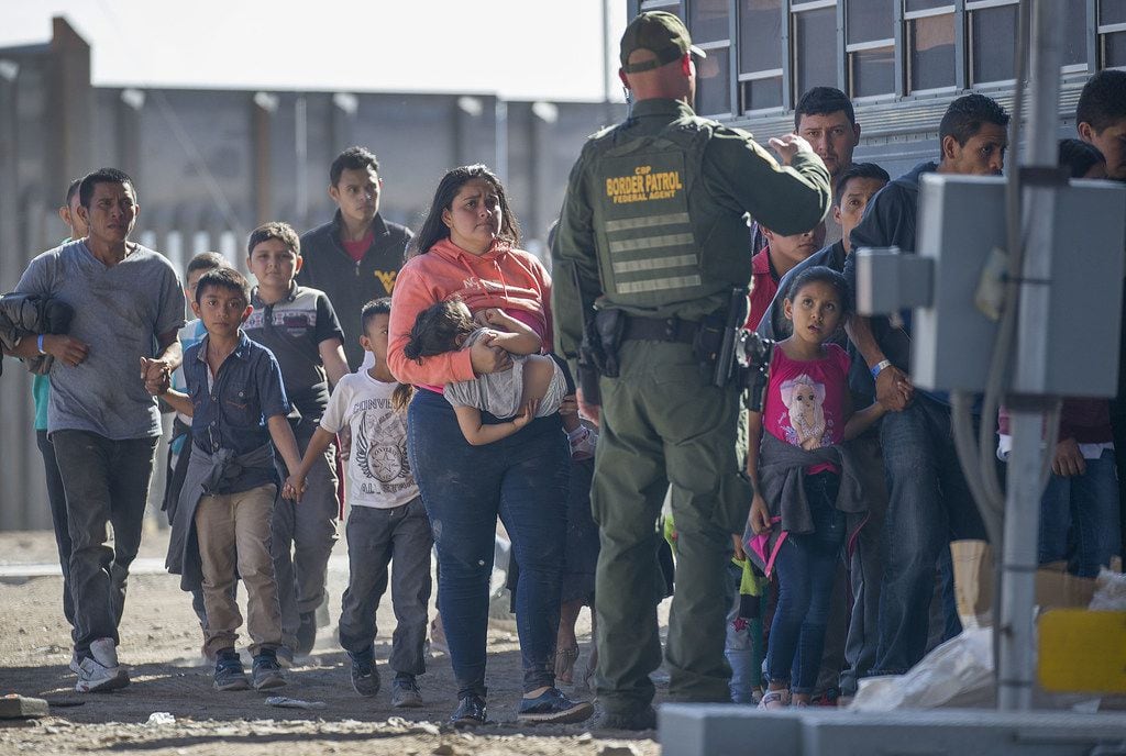 Migrants are loaded onto a bus by U.S. Border Patrol agents after being detained when they crossed  into the United States from Mexico on June 01 in El Paso.
