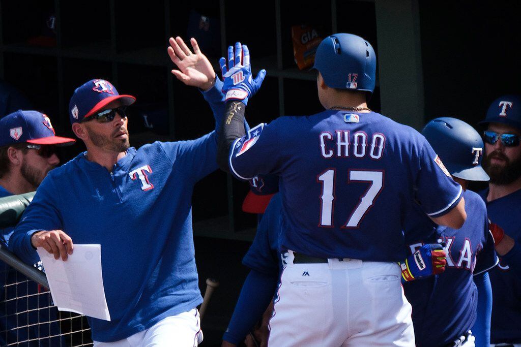 Texas Rangers outfielder Shin-Soo Choo (17) gets a high five from manager Chris Woodward...