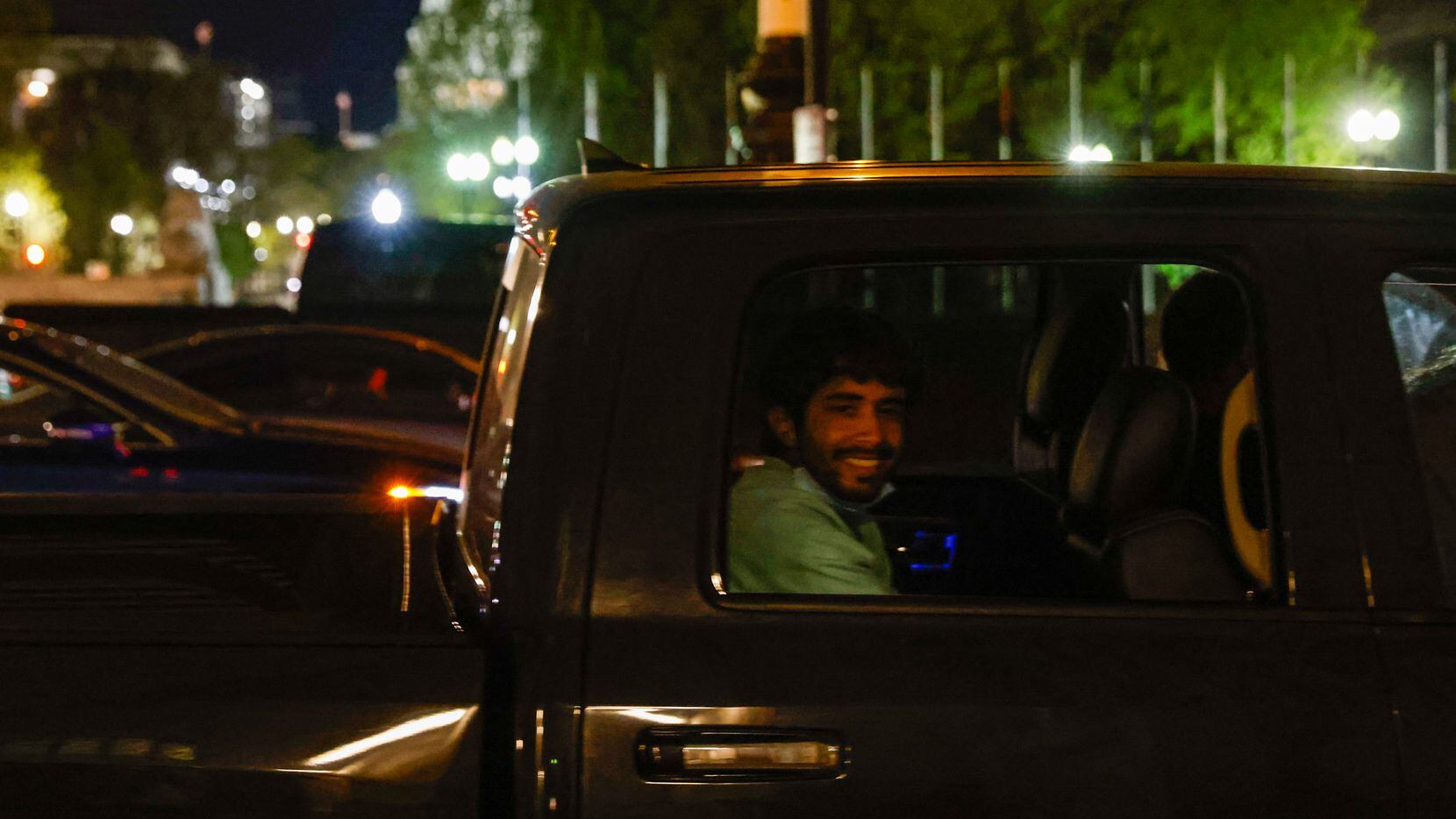 Victor Rodriguez, 26, smiles in the back of Maria and Diego Mena's pick-up truck as they...