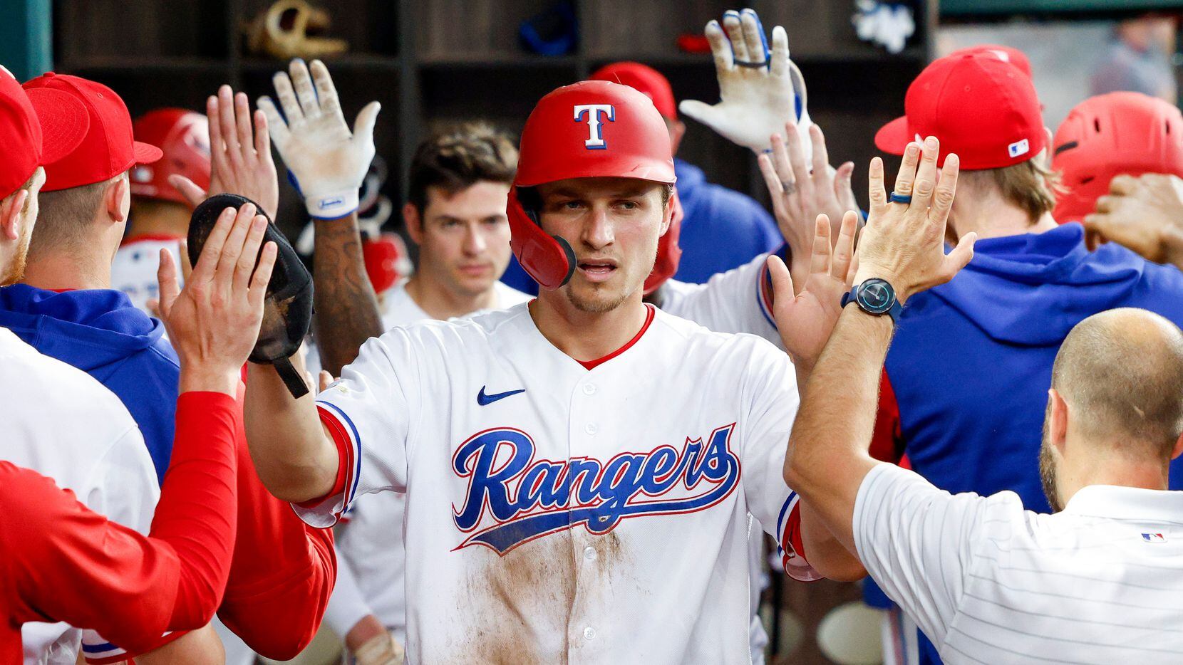 Texas Rangers shortstop Corey Seager (5) high-fives his teammates in the dugout after...