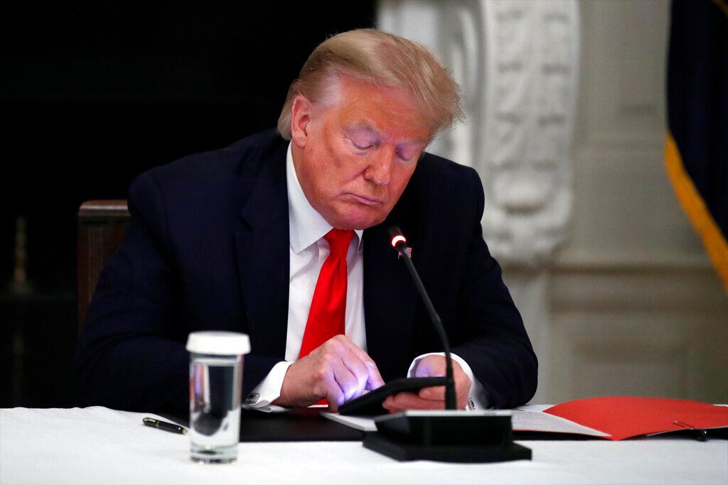 Fotografía del jueves 18 de junio de 2020 del presidente Donald Trump viendo su celular...