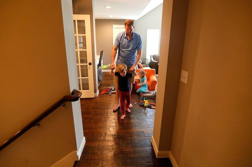 Doug Woleben helps his son, Will, walk to his bedroom at their home in McKinney, Texas,...