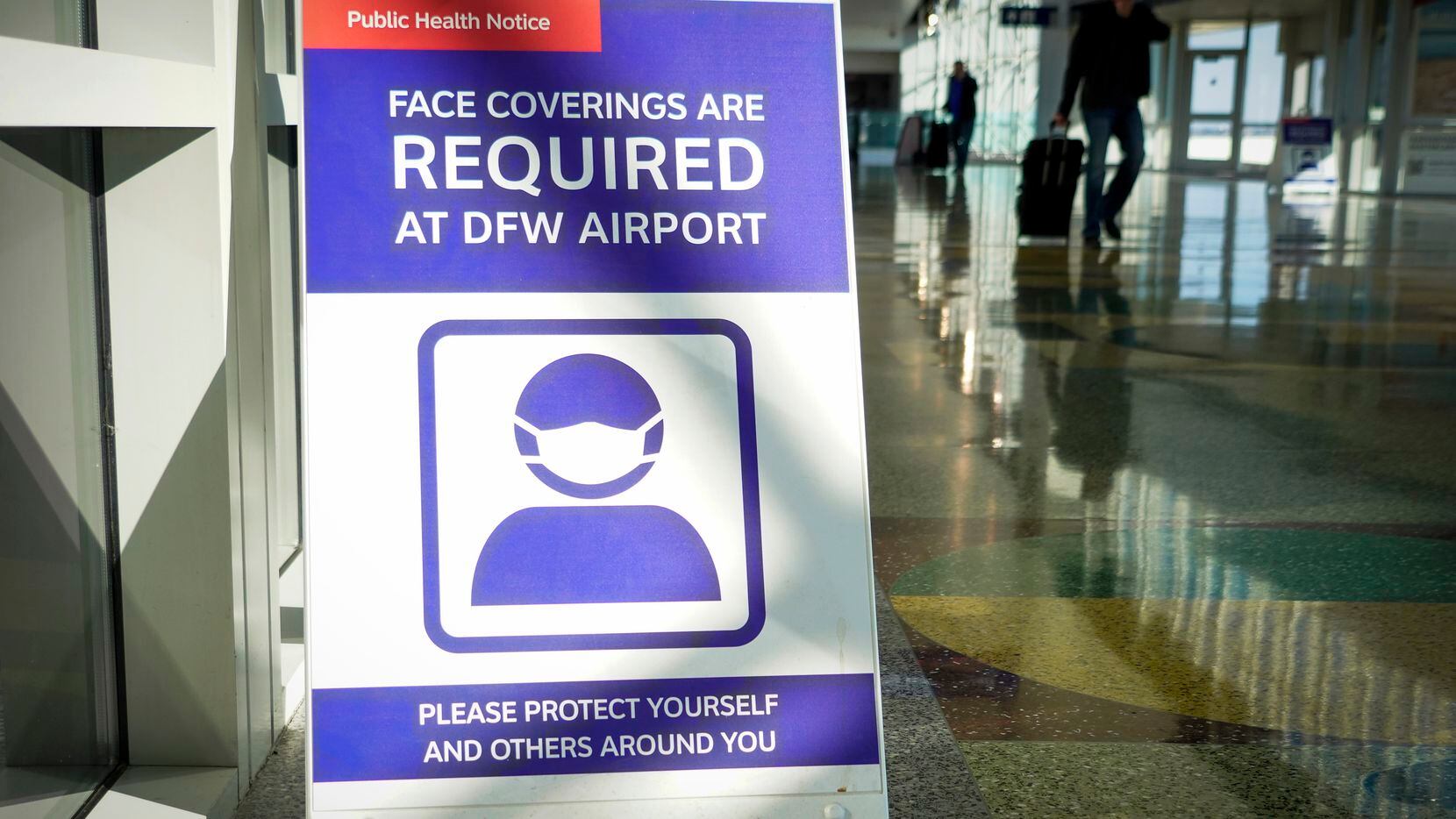 U cartel en el Aeropuerto DFW indica que debe utilizarse mascarilla dentro del lugar por la...