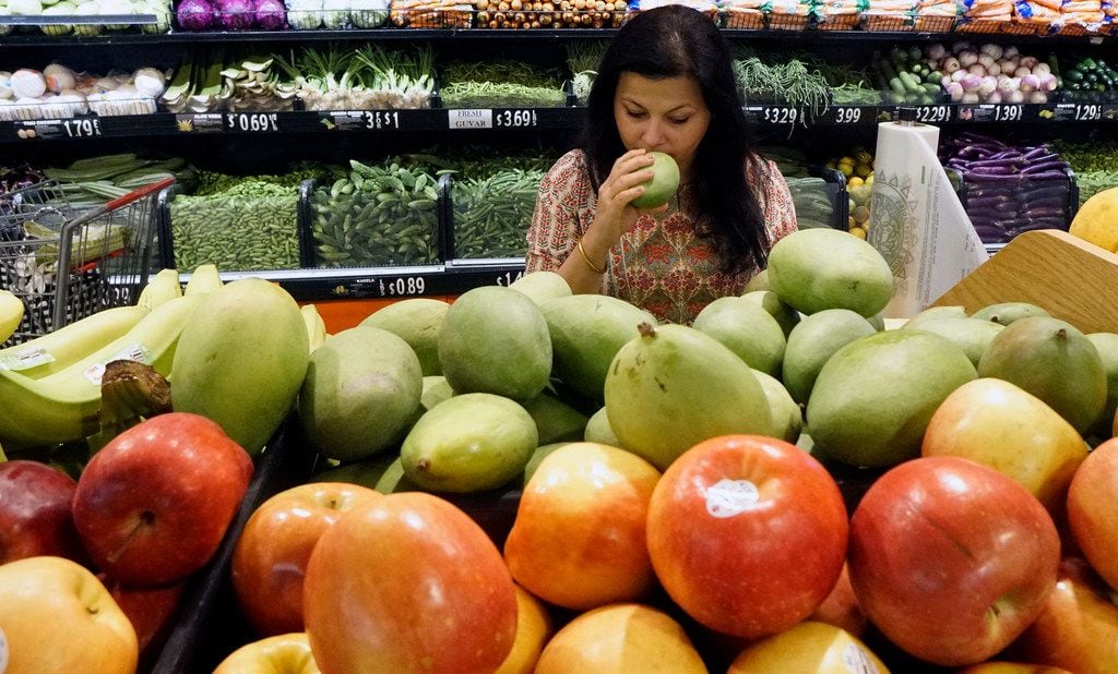 Sapna Punjabi-Gupta checks out the green raw mango at the India Bazaar in Irving, Texas on Tuesday, March 26, 2019.  (Lawrence Jenkins/Special Contributor)