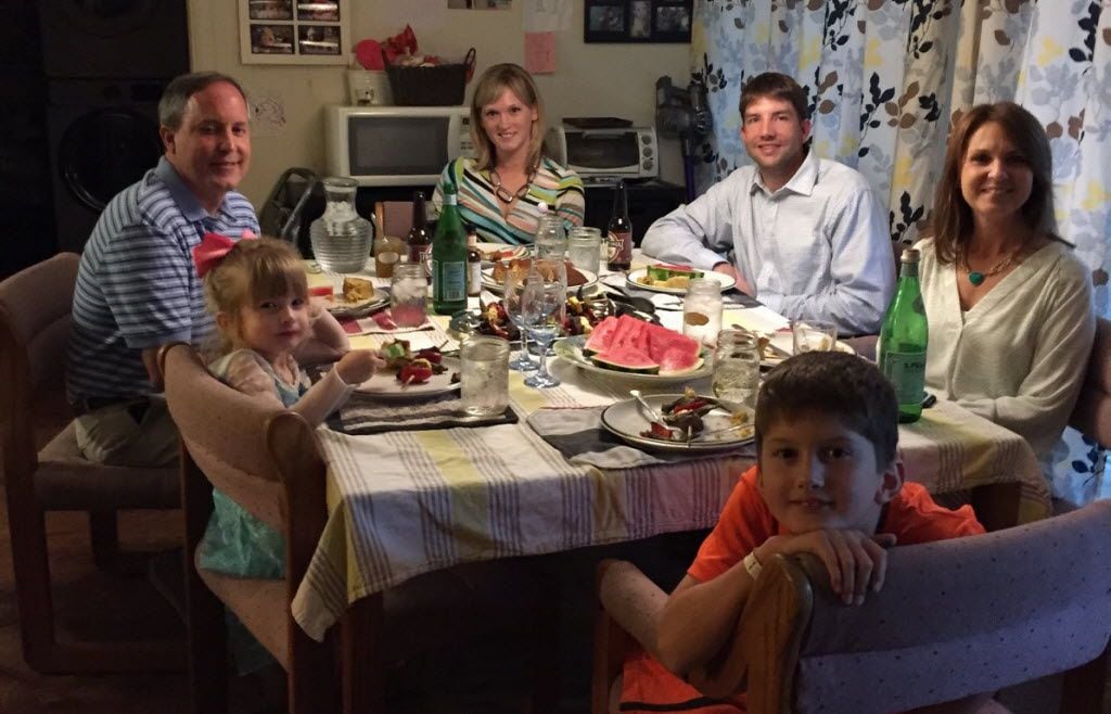 Texas Attorney General Ken Paxton (left)  and his wife, Angela, join the Briggle family — Adam, Amber and their children Lulu (next to Paxton) and MG —  for dinner in Denton. 