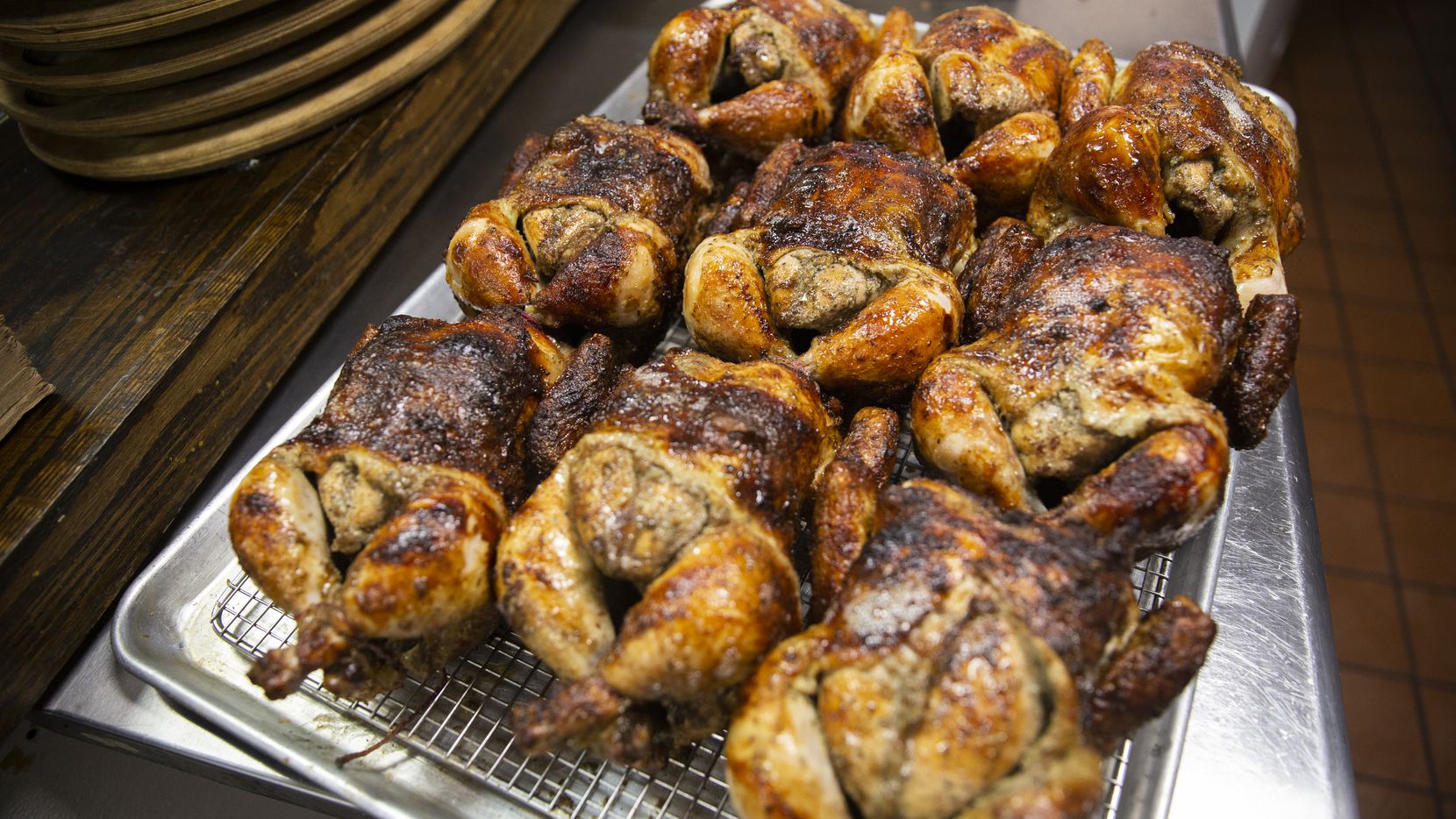 The pollo a la brasa (Peruvian roasted chicken) comes out of the oven at the Brasa Bar and...