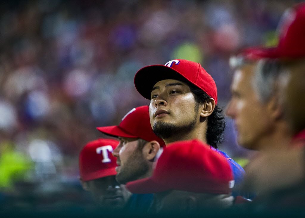 Texas Rangers pitcher Yu Darvish (11) watches from the dugout during the fifth inning of...