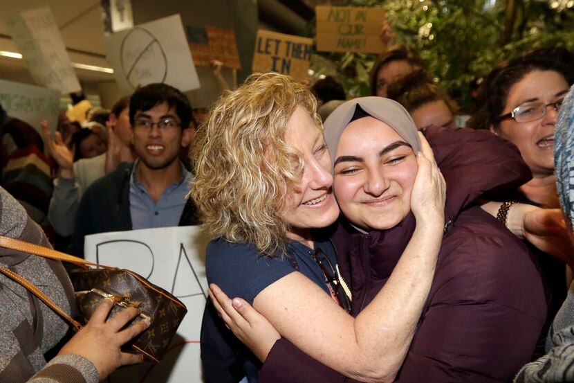 Demonstrators embrace in front of the arrivals terminal at San Francisco International...