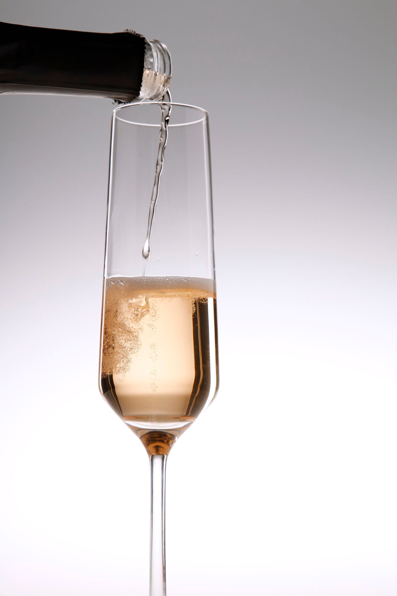 A sparkling rose wine from Spain is poured into a Champagne glass
