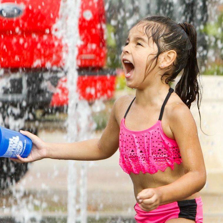 Analia Valentin runs through a fountain at at the Wildflower! Arts & Music Festival on May...