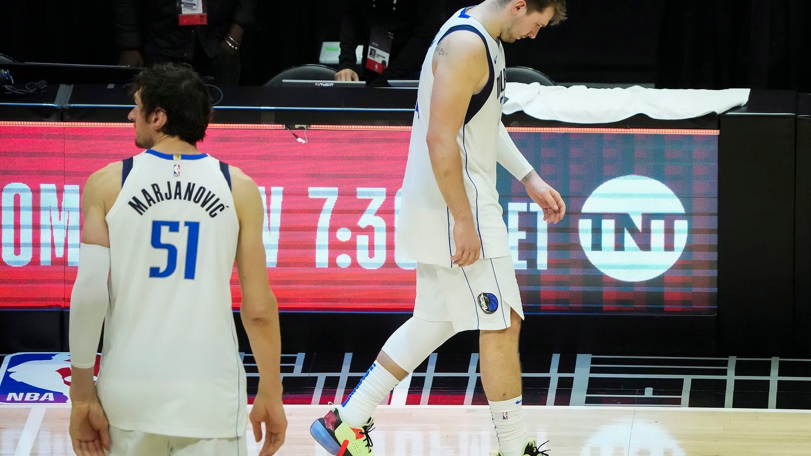 Dallas Mavericks guard Luka Doncic and center Boban Marjanovic walk off the court after a...