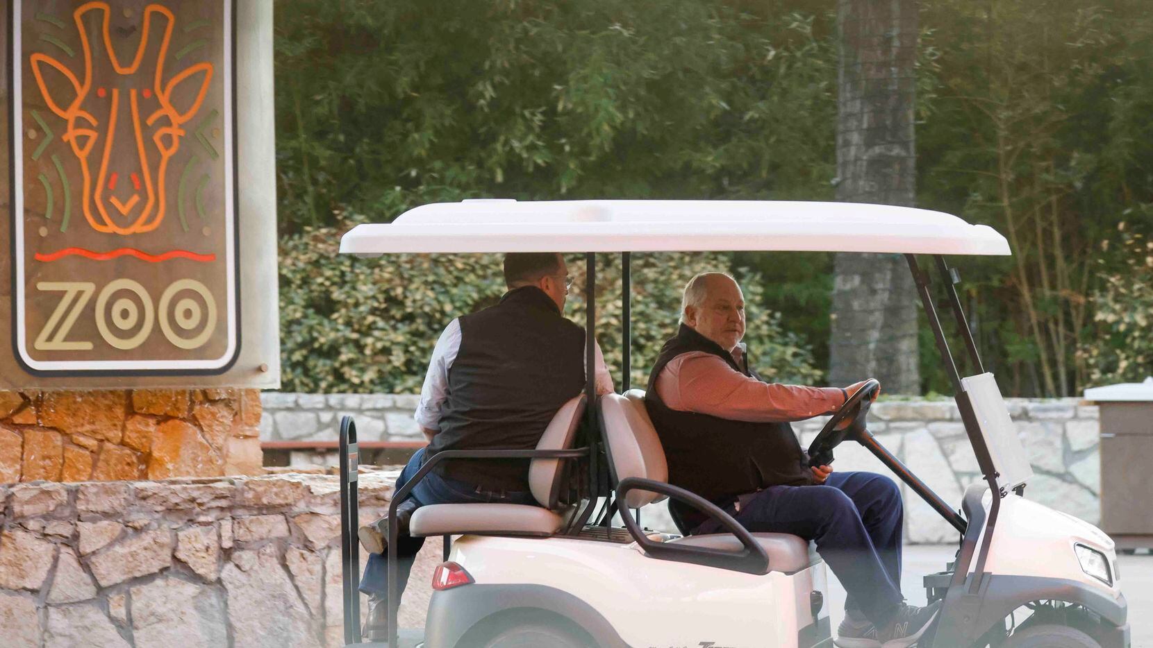 Dallas Zoo President and CEO Gregg Hudson, right, drives a cart with Harrison Edell,...