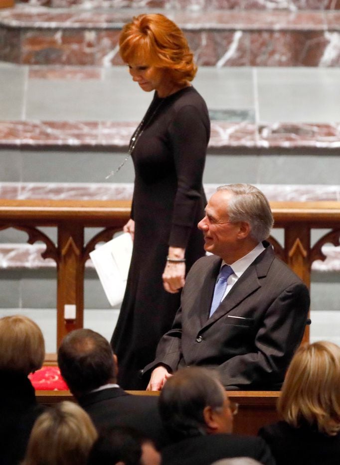Country music legend Reba McEntire passes by Texas Governor Greg Abbott as she leaves the...