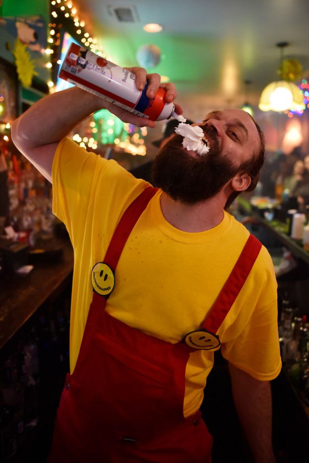 Bartender Chase Fieber jugs a can of whip cream while working the bar inside the pop-up bar...