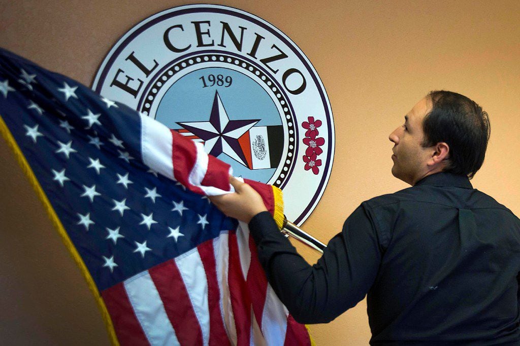 El Cenizo Mayor Raul Reyes places the American flag next to the city seal as he sets up the...