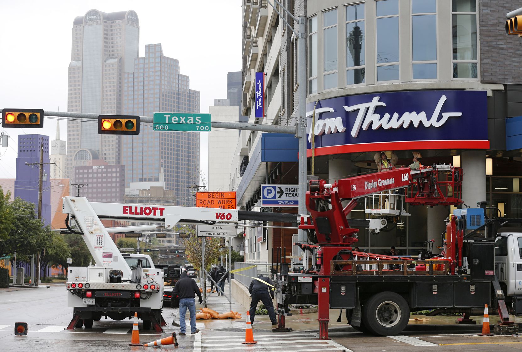A construction crew works on the sign in front of the Tom Thumb grocery store in downtown...