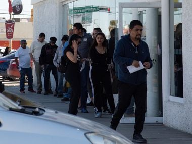 People line up to use an ATM in Ciudad Juarez, Mexico, March 25,2020. Unlike in the bordering city of El Paso, Many in Juarez have not taken warnings to stay home as seriously.