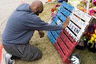 Jay Lewis, of Allen, prays at the memorial honoring the victims of a mass shooting at the...