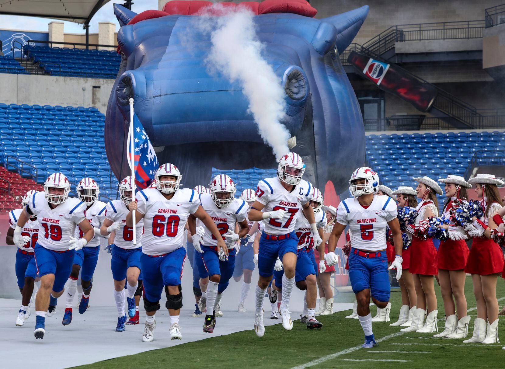 Grapevine High School players run on the field at Toyota Stadium before the football game...