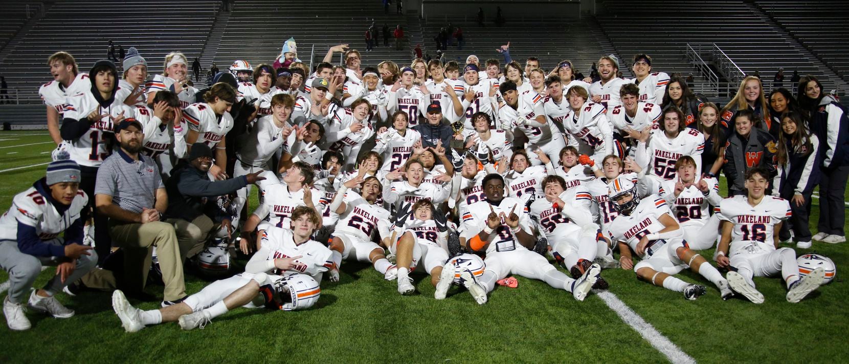 Frisco Wakeland players, coaches and staff members pose after their 38-7 victory over Dallas...