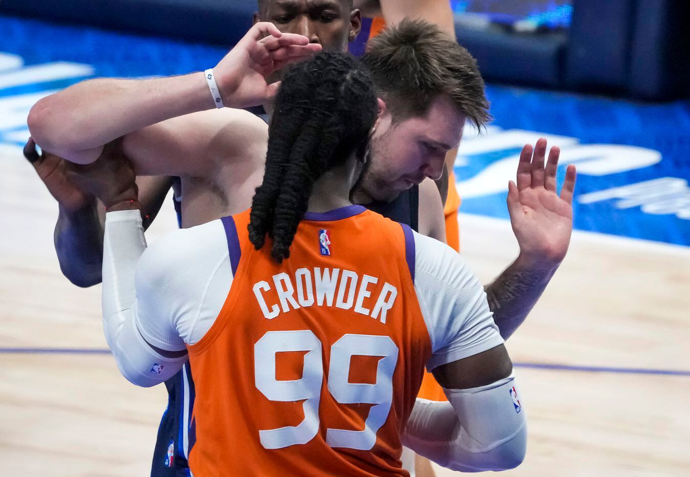 Dallas Mavericks guard Luka Doncic (77) gets tangled with Phoenix Suns forward Jae Crowder...
