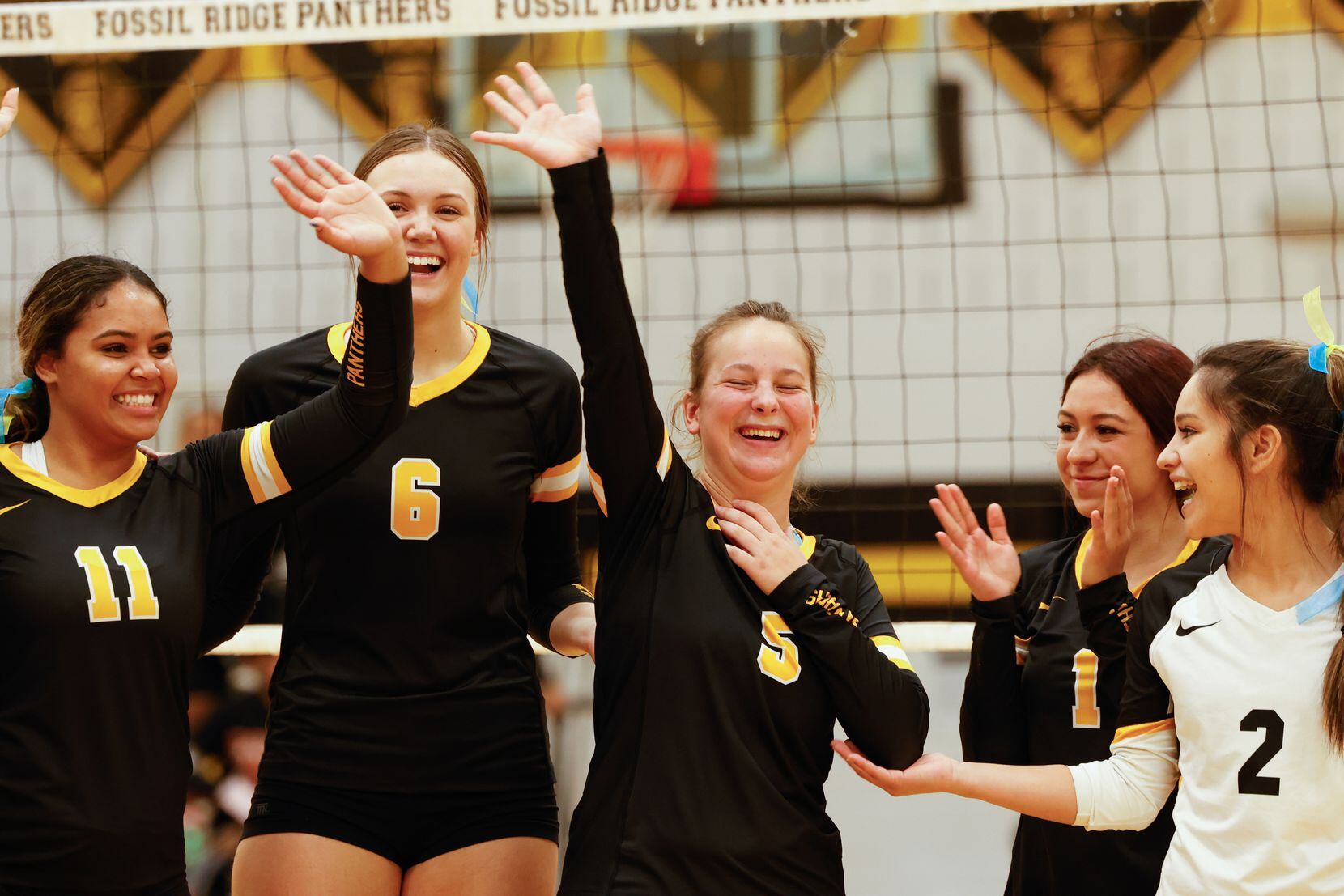 Fossil Ridge High School defensive specialist Ruslana Plaksii (5) waves to her family as...
