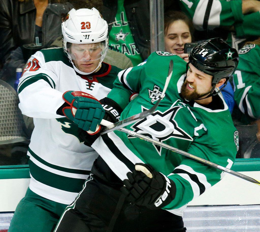 The Dallas Stars' Jamie Benn (14) tries to break free from the Minnesota Wild' Ryan Suter (20) during the third period at the American Airlines Center in Dallas on Saturday, Feb. 3, 2018. The Stars won, 6-1. (Tom Fox/Dallas Morning News/TNS)