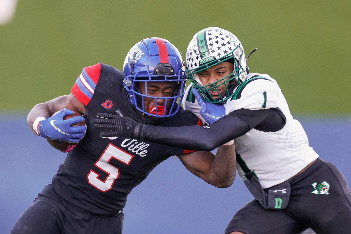 Southlake Carroll defensive back Avyonne Jones (1) tackles Duncanville running back Malachi Medlock (5) during the first half of their Class 6A Division I state semifinal playoff game at McKinney ISD Stadium in McKinney, Texas, Saturday, Dec. 11, 2021. (Elias Valverde II/The Dallas Morning News)