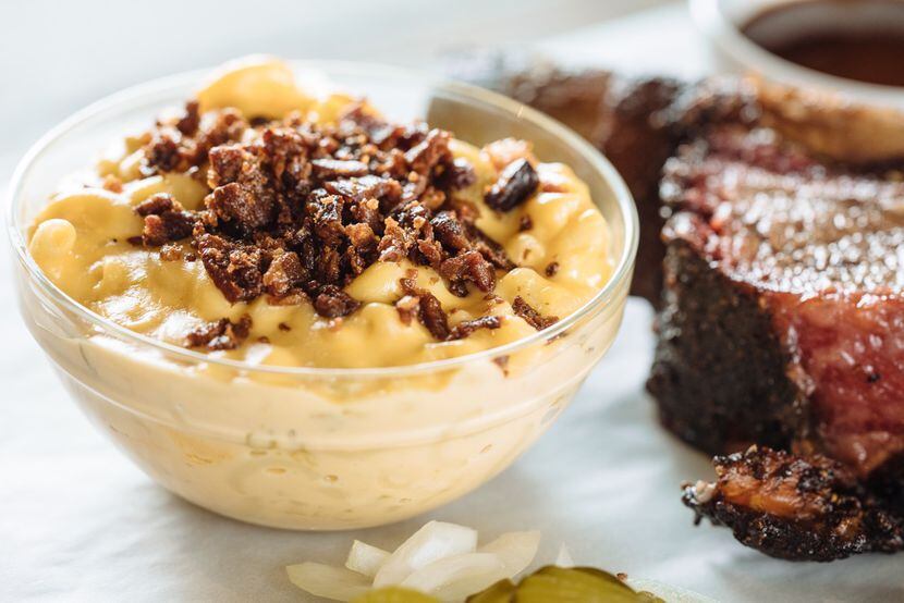 The mac and cheese at Pecan Lodge in Dallas is a creamy version topped with bacon.
