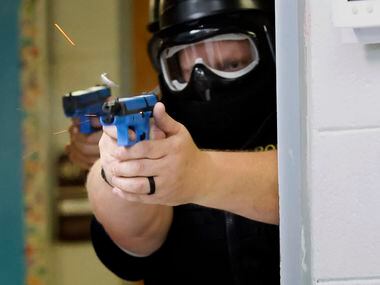 Athens Police Officer Roger Keith fires a soap-based marking cartridge at an active shooter...