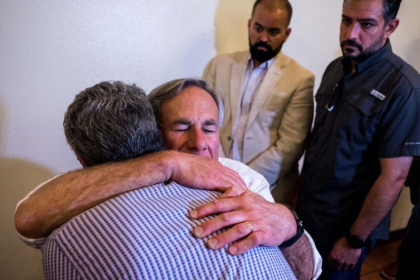 Texas Gov. Greg Abbott hugs El Paso resident Antonio DeAnda, 70, after a vigil ceremony at...