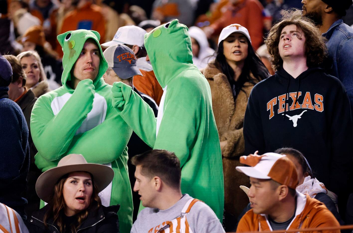 TCU fans dressed as frogs fist bump one another after another good play against the Texas...