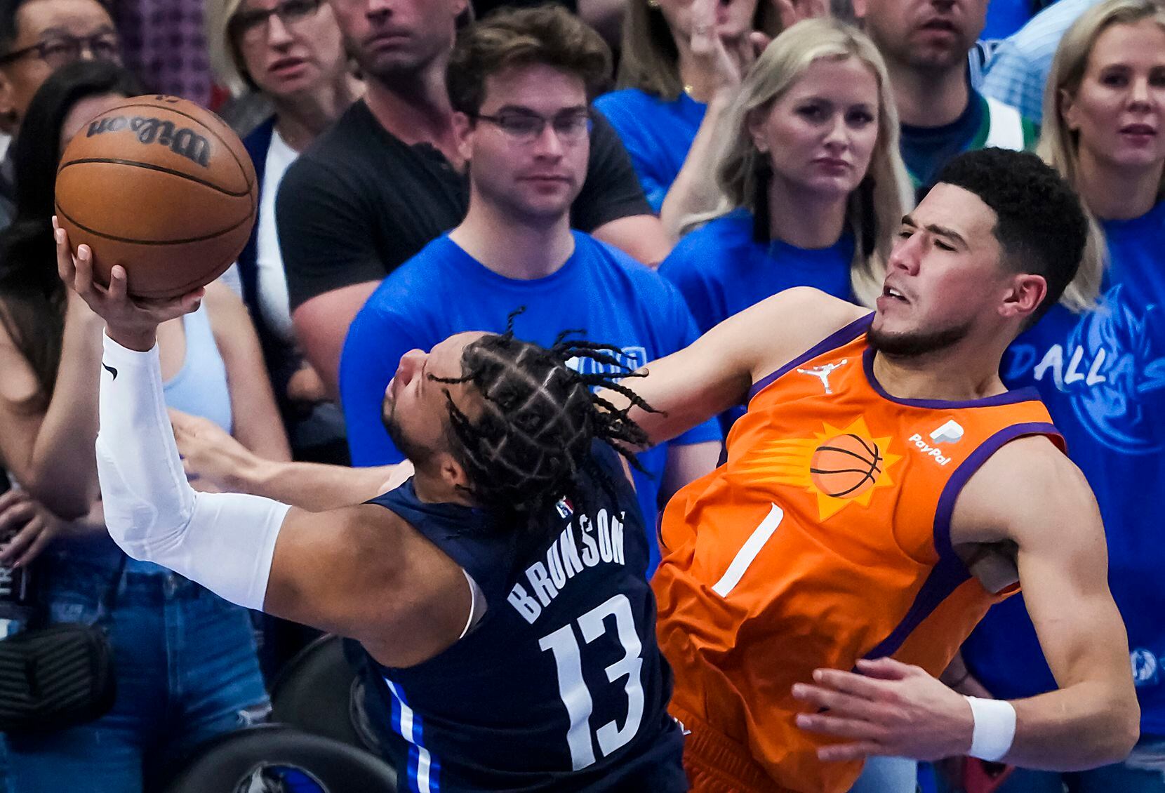 Dallas Mavericks guard Jalen Brunson (13) is fouled by Phoenix Suns guard Devin Booker (1)...