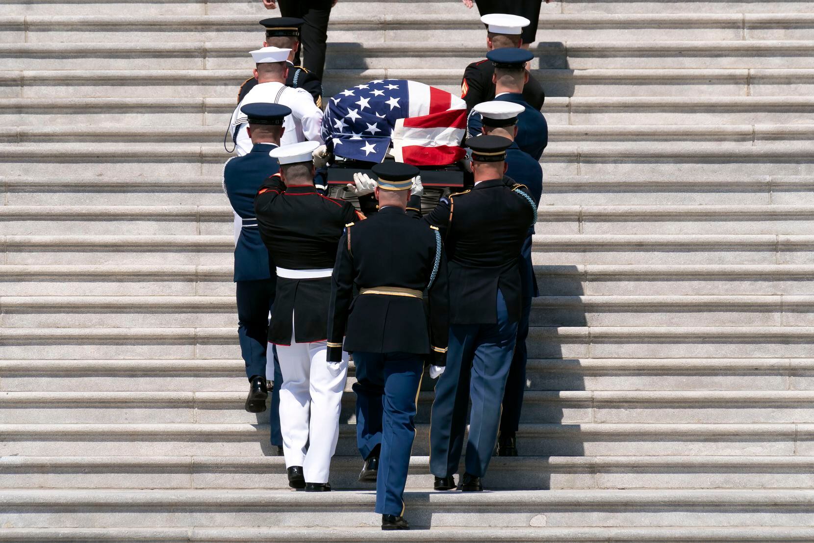 The flag-draped casket bearing the remains of Hershel W. "Woody" Williams is carried by...