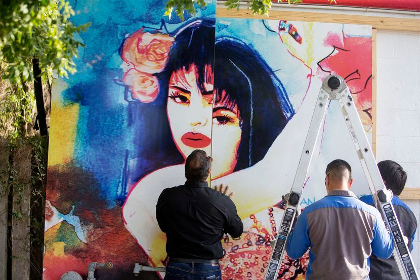 Trabajadores instalan un nuevo mural de Selena afuera de una tienda de comida en Molina,...