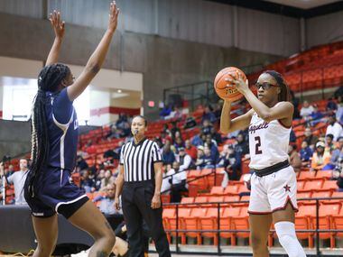 Coppell sophomore guard Londyn Harper (20) looks for an open teammate while being defended...