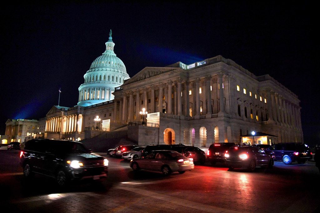 Various cars and SUVs being driven by or carrying U.S. senators leave the area near the...