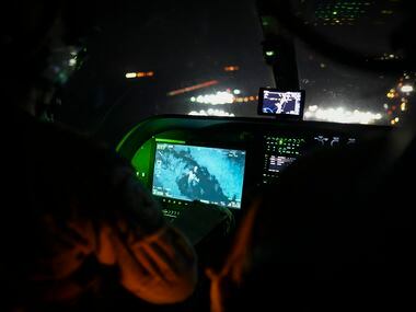 Texas Department of Public Safety tactical flight officer Jaclyn Gooding tracks the movement...