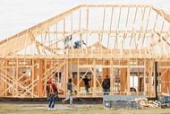 Construction workers frame a new house from Camden Homes along FM 3080 in Mabank.