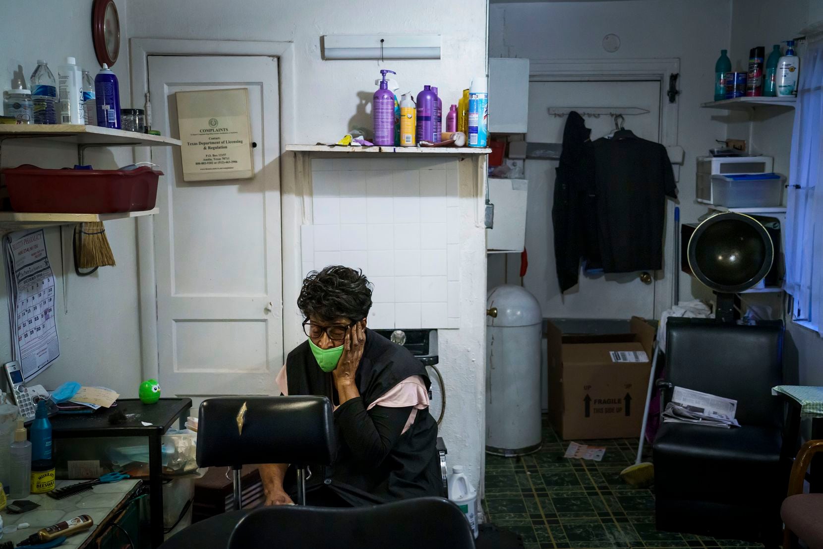 Earnestine Tarrant collects herself as she packs up after her final client, on her final working day before retirement, at her hair salon.