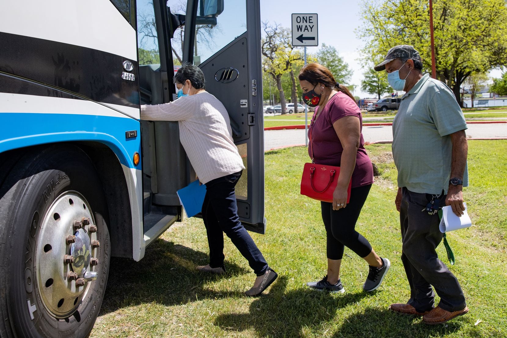 María Figueroa (center) and Raul Figueroa (right) prepare to load the bus from Bachman Recreation Center to receive the COVID-19 vaccine at Fair Park.