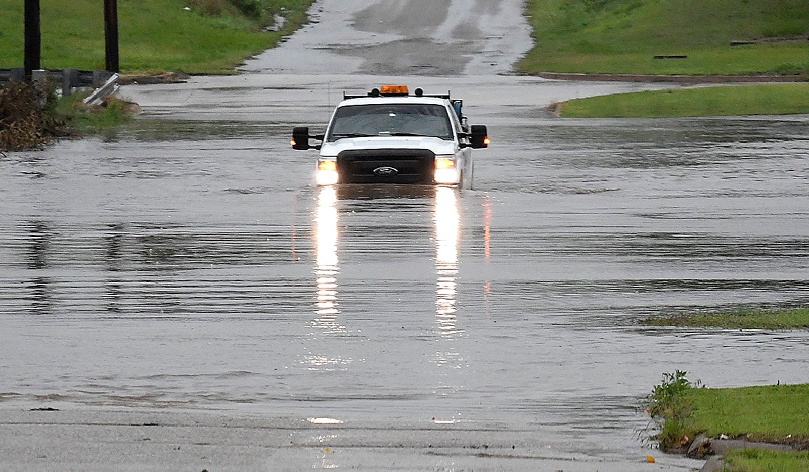 A pickup drives on a flooded street in Enid, Okla., on Monday, May 20, 2019. An intense...